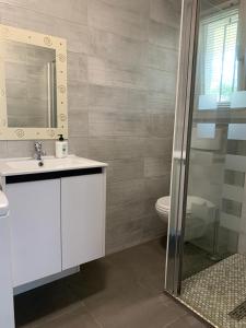 un bagno con lavandino, WC e specchio di T2 proche des 2 Jumeaux a Hendaye