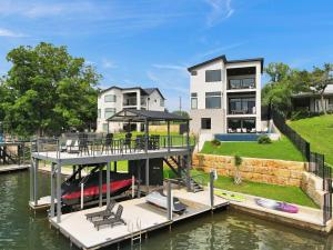 a house with a dock with a boat in the water at The Escape at 212 with Concierge Services in Burnet
