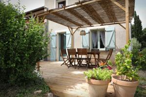 a wooden deck with chairs and a table on it at Gîte " Ô PARADIS" in Douelle