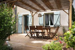 a wooden deck with a table and chairs on it at Gîte " Ô PARADIS" in Douelle