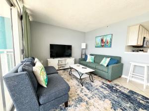 a living room with two couches and a tv at Oceanfront 2BR King Suite Atlantica Resort in Myrtle Beach +40 photos