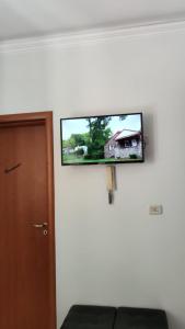 telewizor z płaskim ekranem wiszący na ścianie obok drzwi w obiekcie La casa di Antonia w Katanii