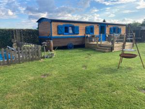 a tiny house in a yard with a swing at Puck B&B Babbita in Hasselt