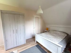 プルームール・ボドゥーにあるMaison avec WIFI, jardin clos, terrasse, à 600m de la plage - Pleumeur-Bodou - FR-1-368-425の白いベッドとクローゼットのある寝室