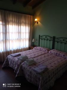 a bedroom with a bed with purple sheets and a window at Casa Rural Llendelriu in Villahormes