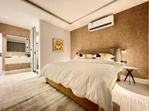 a bedroom with a large bed and a bathroom at C Living - Executive - AQIQ in Riyadh