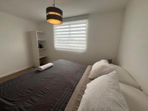 a bedroom with a large bed with a window at Casa acogedora en Romeral in Romeral