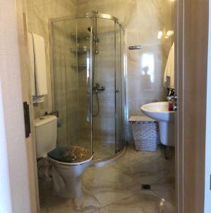 a bathroom with a shower and a toilet and a sink at Апартамент VESI комплекс ARTUR in Sveti Vlas