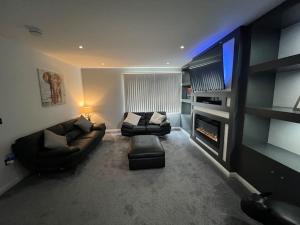 a living room with two couches and a flat screen tv at Ardenslate House in Kirn
