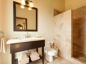 a bathroom with a sink and a toilet and a mirror at La Colina - 4 People in West Bay +17 photos