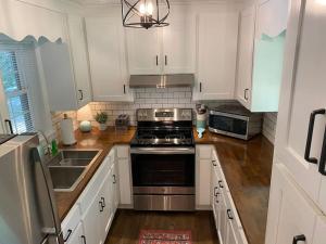 a kitchen with white cabinets and a stove top oven at Pine Valley Place 3 Bedroom 2 Bathroom house in Gainesville