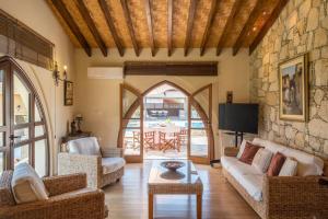 a living room with furniture and a stone wall at Traditional House Agia Varvara Village in Ayvaryara