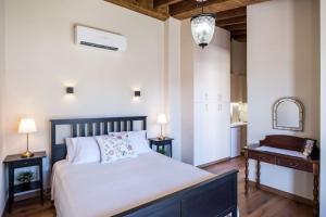a bedroom with a bed and a table and a mirror at Traditional House Agia Varvara Village in Ayvaryara +86 photos