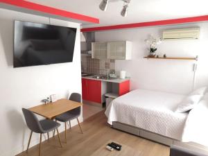 ein Schlafzimmer mit Bett und Tisch und eine Küche in der Unterkunft Acogedor Apartamento Entero in Arcos de la Frontera