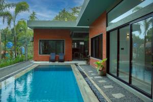 a swimming pool in front of a house at Jack & Rose - Hiriketiya, Haven Garden Properties in Dickwella