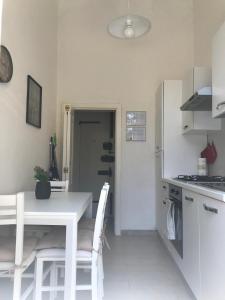 フィレンツェにあるLa casa di Annaの白いテーブルと椅子のある白いキッチン