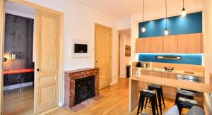 a living room with a fireplace and a kitchen at Appart' Pasteur in Lyon