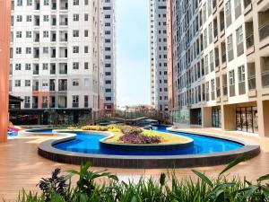 a large fountain in a city with tall buildings at Comfort 2BR at Transpark Juanda Bekasi Timur Apartment By Travelio in Bekasi