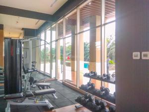a room with a gym with a large window at Comfy and Tidy Studio Transpark Cibubur Apartment By Travelio in Depok