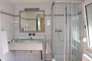 a bathroom with a sink and a shower with a mirror at Hotel Ickhorn in Werne an der Lippe