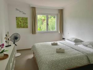 una camera da letto bianca con un letto e una finestra di Camere a "Casa Nostra" ad Ascona
