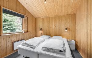 a bedroom with a bed in a wooden wall at Awesome Home In Væggerløse With Kitchen in Marielyst +18 photos