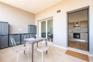 una cucina e una sala da pranzo con tavolo e sedie di Dimora Anna - Exclusive Sea Loft a Bari Altre 13 foto