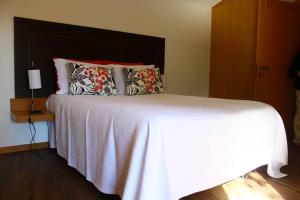 a bedroom with a large white bed with pillows at As Casinhas de Loureda in Arcos de Valdevez +50 photos