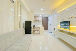 a living room with a couch and a kitchen at Brand New and Modern 2BR at Daan Mogot City Apartment By Travelio in Jakarta