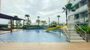 a swimming pool with a slide in a building at Brand New and Modern 2BR at Daan Mogot City Apartment By Travelio in Jakarta