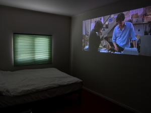 a bedroom with a bed and a tv on the wall at Chungking Mansions Busan in Busan