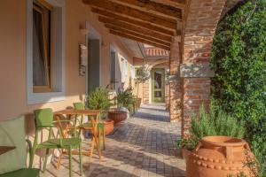 塞扎纳阿珀洛尼佳住宅旅馆的一个有桌椅的户外露台和一座砖砌建筑