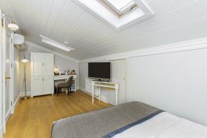 a bedroom with a bed and a desk with a television at Meroddi Galata Mansion in Istanbul