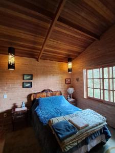 une chambre avec un grand lit dans une pièce en bois dans l'établissement CASA EM MONTE VERDE CHARME E CONFORTO, à Monte Verde