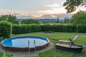 a swimming pool in a yard with a bench and a table at Villa Sajkod in Tihany
