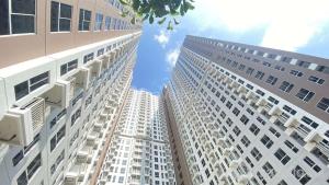 two tall white buildings looking up at the sky at Compact and Tidy Studio at Tokyo Riverside PIK 2 Apartment By Travelio in Rawalembang