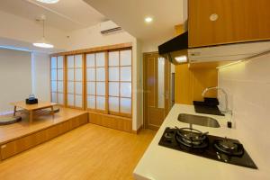 a kitchen with a stove and a counter top at Spacious and Homey 1BR Tokyo Riverside PIK 2 Apartment By Travelio in Rawalembang