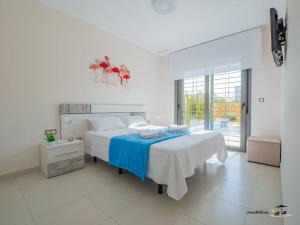 ein weißes Schlafzimmer mit einem großen Bett mit blauer Bettwäsche in der Unterkunft Apartment Perla del Sol in Arenales del Sol + 22 Fotos