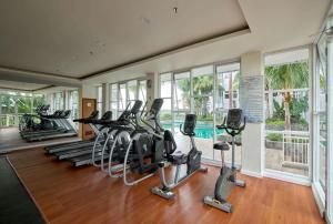 a gym with a row of treadmills and ellipticals at Modern Designed 2BR at Vida View Makassar Apartment By Travelio in Pampang