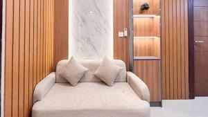 a couch with pillows on it in a room at Modern Designed 2BR at Vida View Makassar Apartment By Travelio in Pampang +19 photos