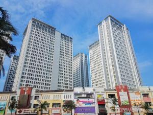 three tall white buildings in a city at New Furnished Studio Apartment at M-Town Residence By Travelio in Pumpangsineng