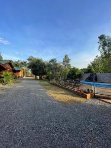 伊瓜苏港Cabañas Josesito的有长椅和栅栏的碎石路