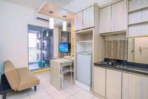 a kitchen with a desk and a computer in a room at Best Deal 3BR Apartment M-Town Residence near Summarecon Mall By Travelio in Tangerang