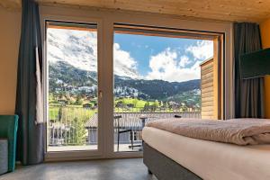 a bedroom with a bed and a view of a mountain at Eiger Lodge Chic in Grindelwald +37 photos