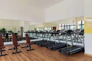 a gym with a row of treadmills and chairs at Comfy Stay Studio at Sky House BSD Apartment By Travelio in Tangerang