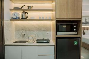 当格浪Good and Homey Studio at Pacific Garden Alam Sutera Apartment By Travelio的带水槽和微波炉的小厨房