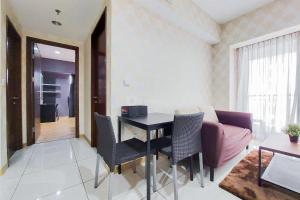 a living room with a table and a couch at Comfort Stay 2BR at M-Town Signature Apartment By Travelio in Tangerang