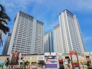 three tall white buildings in a city at Comfort Stay 2BR at M-Town Signature Apartment By Travelio in Tangerang