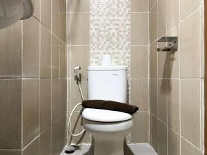 a bathroom with a toilet with a towel on it at Enjoy Living Studio at Enviro Apartment By Travelio in Cikarang +16 photos