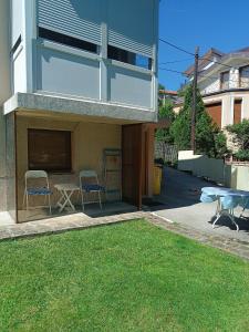 a house with two chairs and a table in a yard at Bolero apartman in Sarajevo